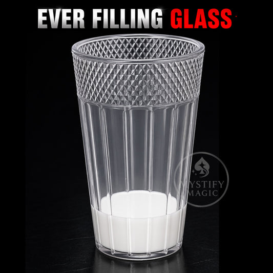 Transparent magic glass full of milk for the Ever Filling Glass trick.
