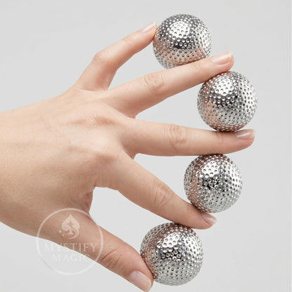 Silver spiked multiplying balls for stage magic manipulation.