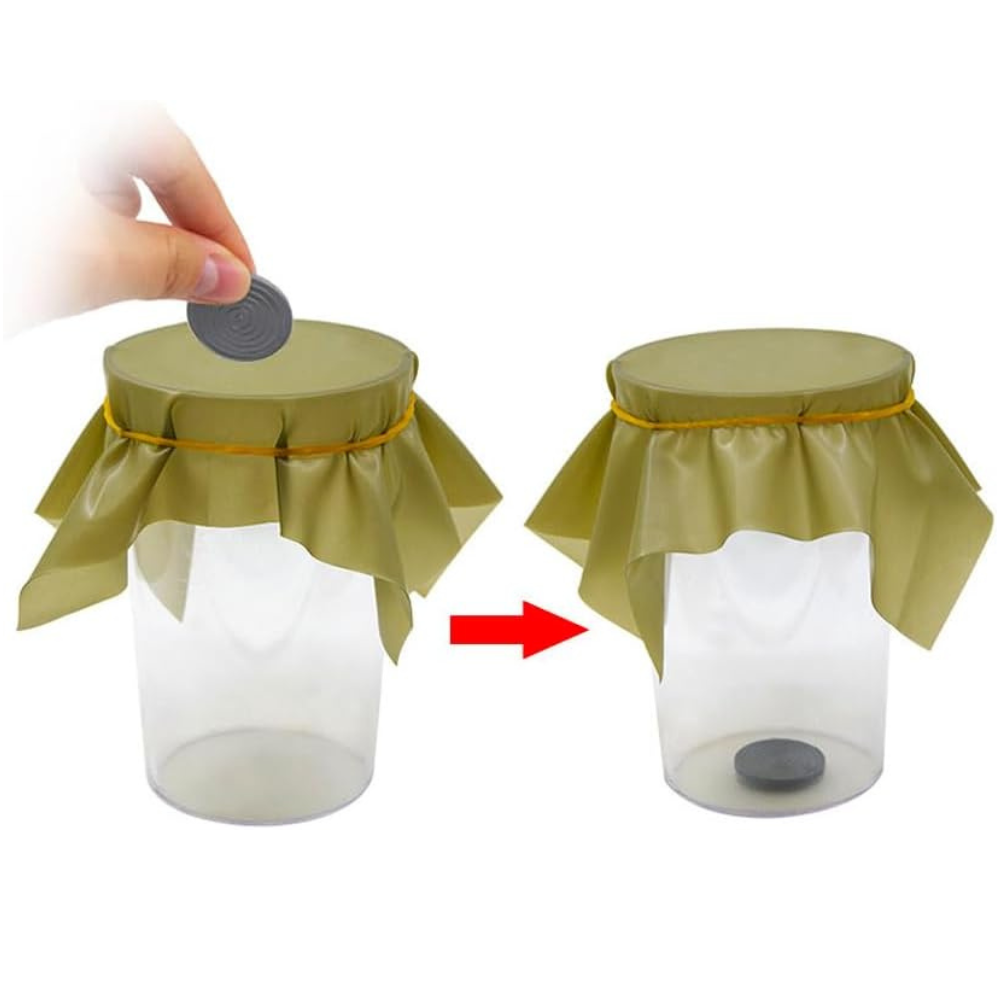 Pena Coin magic trick showing a coin resting on a rubber sheet.